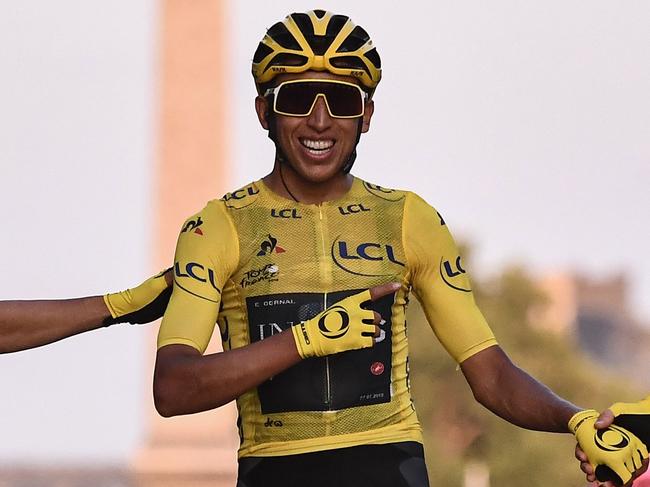 TOPSHOT - Spain's Jonathan Castroviejo (L) and Great Britain's Geraint Thomas (R) congratulate Colombia's Egan Bernal (C), wearing the overall leader's yellow jersey, as he celebrates his victory on the finish line of the 21st and last stage of the 106th edition of the Tour de France cycling race between Rambouillet and Paris Champs-Elysees, in Paris, in Paris on July 28, 2019. (Photo by Anne-Christine POUJOULAT / AFP)