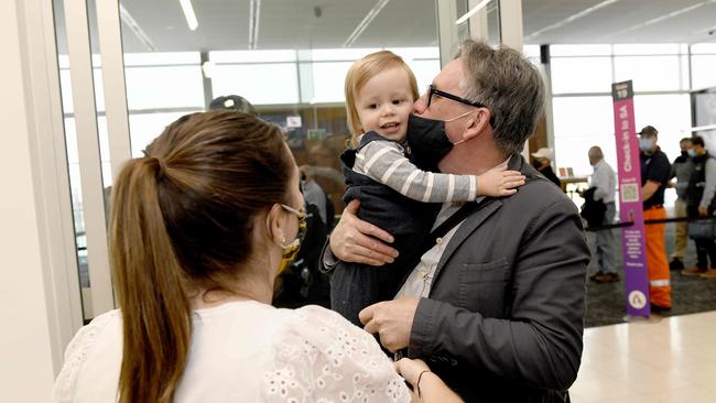 Mark Oliver arrives on the first flight from Sydney, and holds his granddaughter. Picture: Naomi Jellicoe