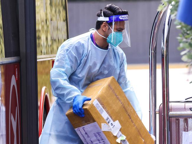 MELBOURNE , AUSTRALIA - NewsWire Photos FEBRUARY 16, 2021 : Hotel quarantine staff unload suitcases of Covid-19 positive people as they arrive at The Pullman Hotel in Albert Park, after being evacuated from the Holiday Inn in the CBD due to water damage. Picture : NCA NewsWire  /  Ian Currie