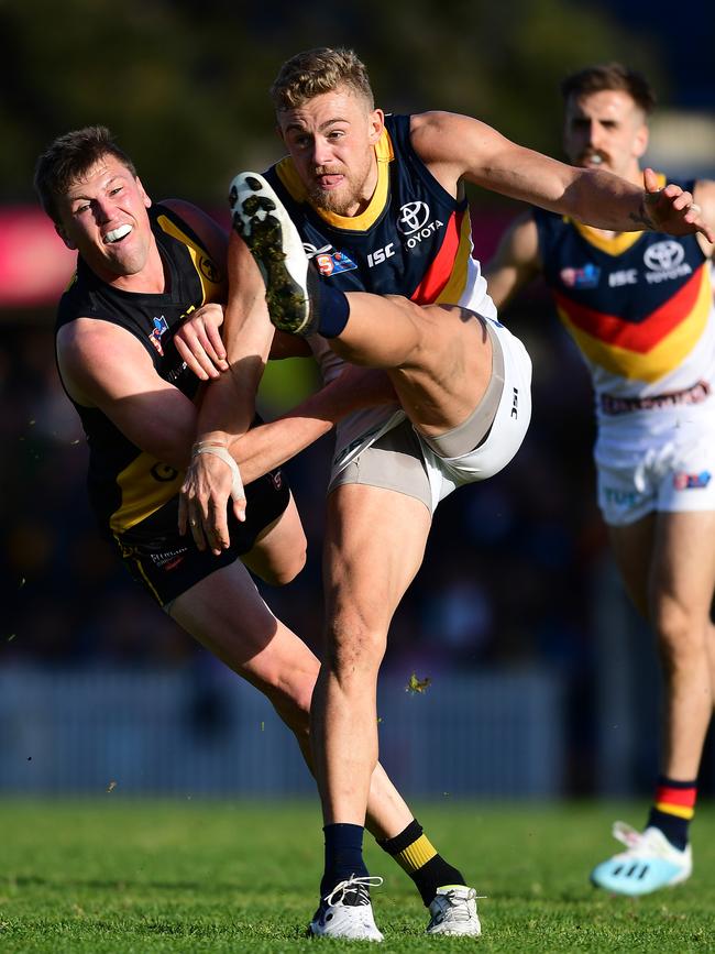 Hugh Greenwood of the Adelaide Crows kicks under pressure from Luke Reynolds in the SANFL on Saturday. Picture: Mark Brake/Getty Images