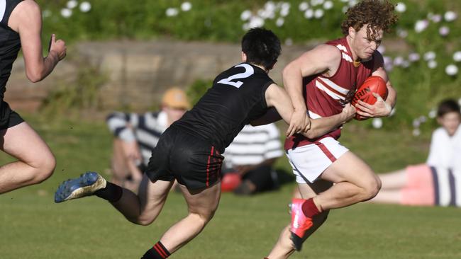 Prince Alfred’s Ben Larsson is tackled by Rostrevor’s Darcy McKenny during their round one college footy clash. Picture: Naomi Jellicoe