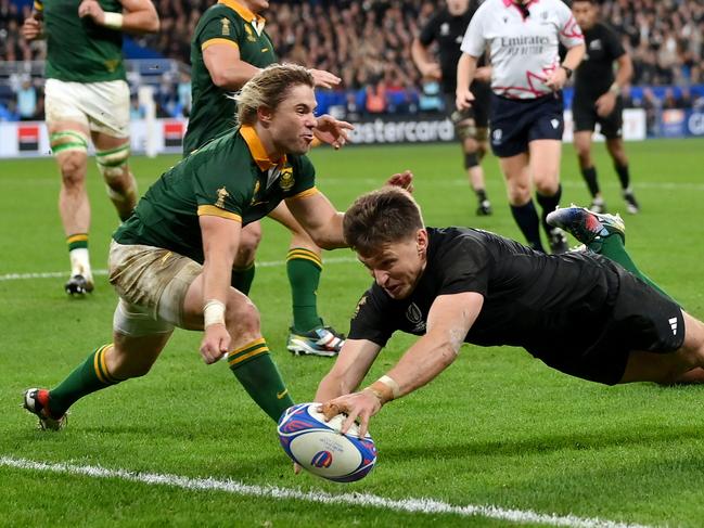 PARIS, FRANCE - OCTOBER 28: Beauden Barrett of New Zealand scores his team's first try whilst under pressure from Faf de Klerk of South Africa during the Rugby World Cup Final match between New Zealand and South Africa at Stade de France on October 28, 2023 in Paris, France. (Photo by Dan Mullan/Getty Images)