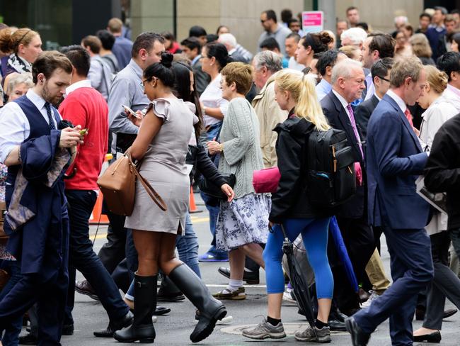 People crowd crossing street in central Sydney. Istock