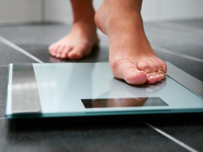 Female bare feet with weight scale in the bathroom, scales generic