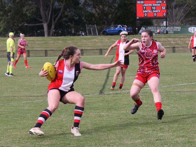 FEROCIOUS FOOTY: At Oakes Oval, Sawtell Saints captain Vienna Schoeffel, tries to avoid determined Swans player Holly Wall, during a hard fought game in the Sir Doug Nicholls Round on May 29, 2021. Photo: Alison Paterson