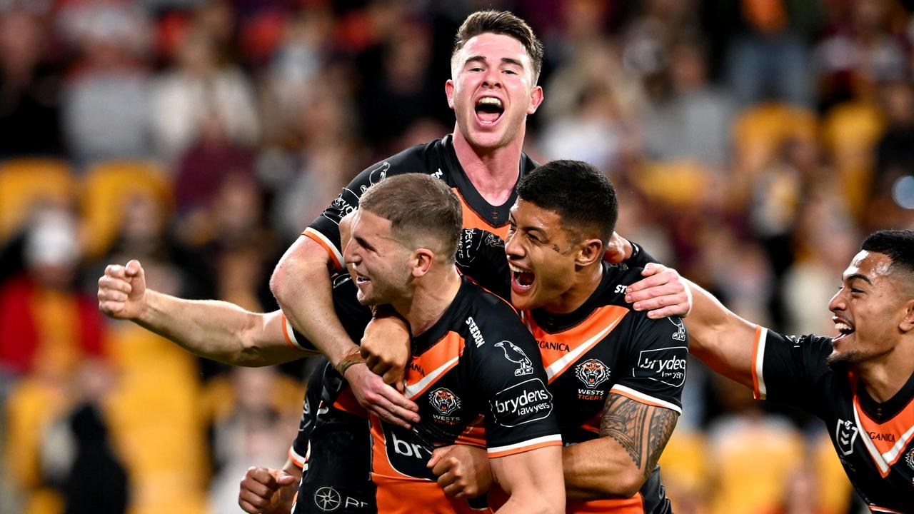 Adam Doueihi is swamped by Tigers’ teammates after scoring the final try. Picture: Bradley Kanaris/Getty Images