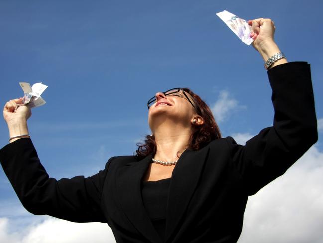 Feeling of success. Generic image of a happy woman looking up at blue sky, holding lottery tickets and smiling.