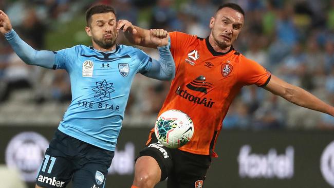 Brisbane Roar captain Tom Aldred (right) competes for the ball with Sydney FC striker Kosta Barbarouses. Picture: AAP