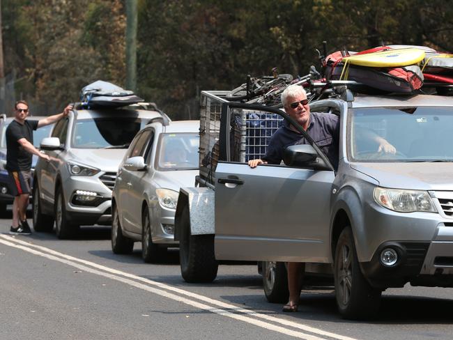 Queues of cars lined up in Manyana on the south coast waiting to be escorted by police and RFS out of the fire-ravaged area. Picture: David Swift