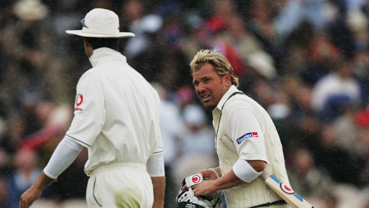 CRICKET – ASHES Tour 2005 – 13.8.05 – 3rd Test – Australia v England at Old Trafford. Shane Warne looks towards Michael Vaughan as the players head off for rain. pic. Phil Hillyard.