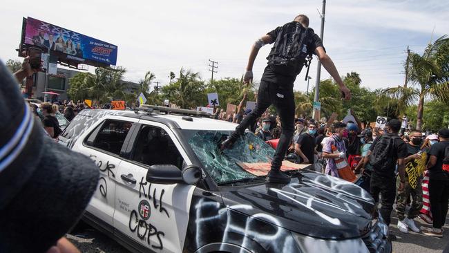 Demonstrators smash a police vehicle in Los Angeles. Picture: AFP