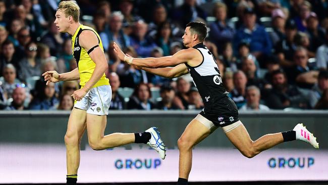 Port Adelaide recruit Ryan Burton pushes Tom Lynch in the back after he kicks the goal, resulting in another free kick and goal for the Richmond star. Picture: Mark Brake/Getty Images