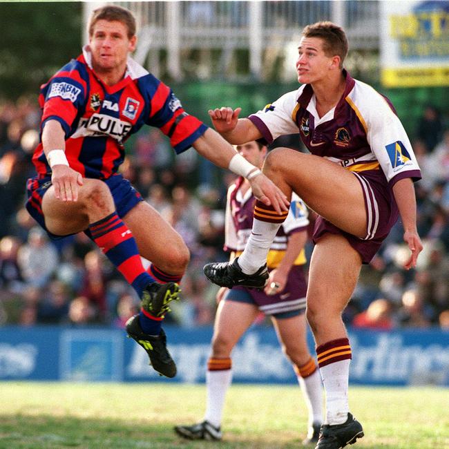 Ashley Harrison gets his kick away despite the attention of the Knights’ Billy Pedan. Picture: Robert McKell