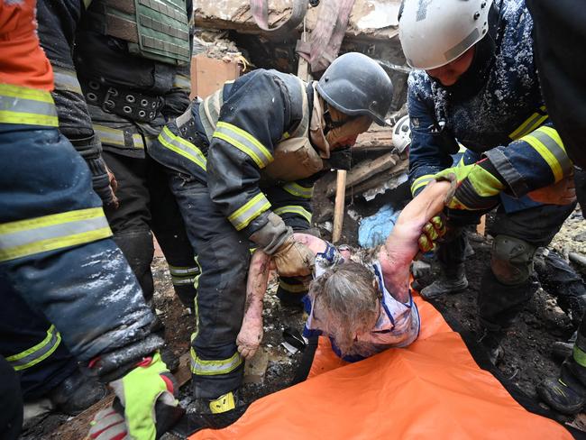 Rescuers and a policeman carry the body of a victim after Russian strikes in Zmiiv, Kharkiv region, on January 8, 2024. Picture: AFP