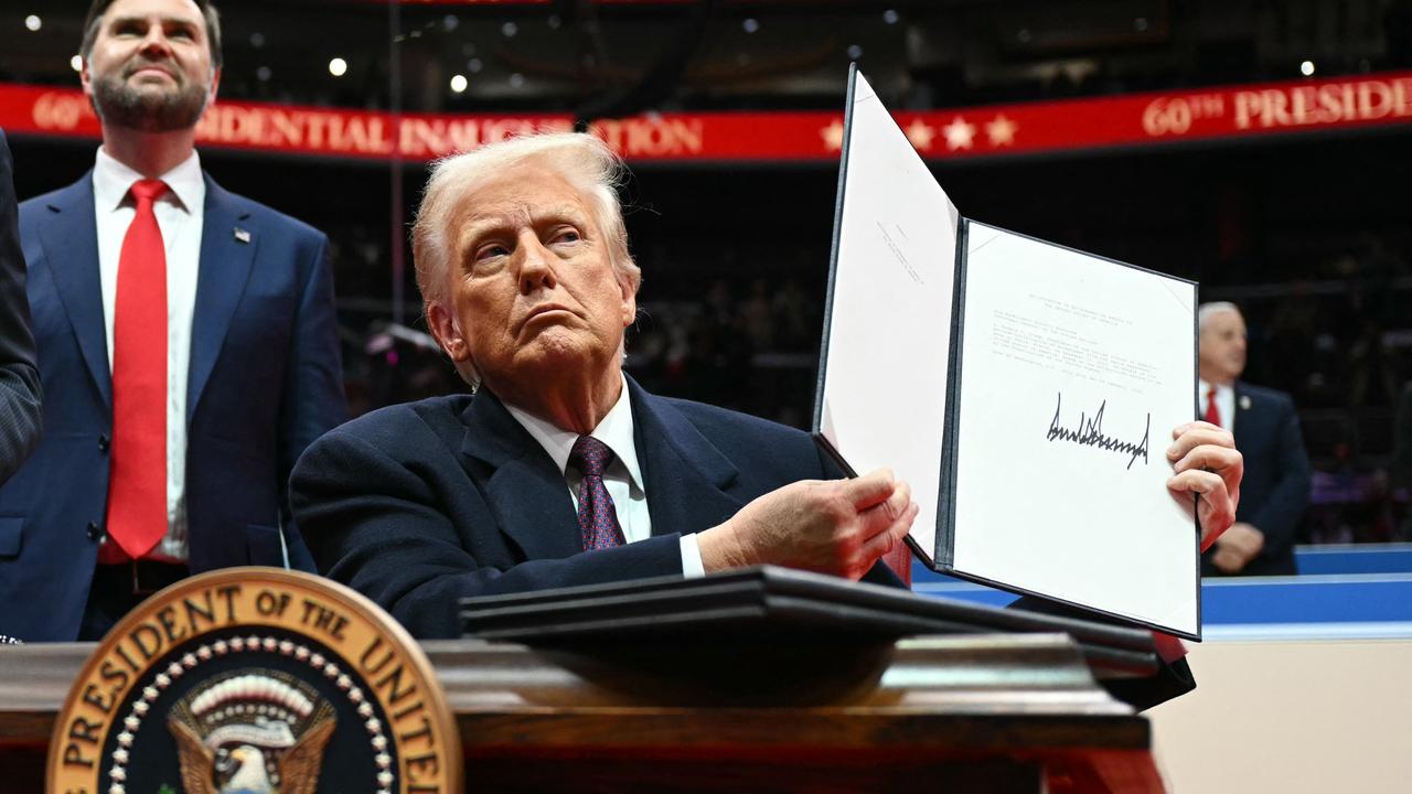 US President Donald Trump holds letter to the UN stating the US withdrawal from the Paris Agreement during the inaugural parade inside Capital One Arena, in Washington, DC, on January 20, 2025. (Photo by Jim WATSON / AFP)