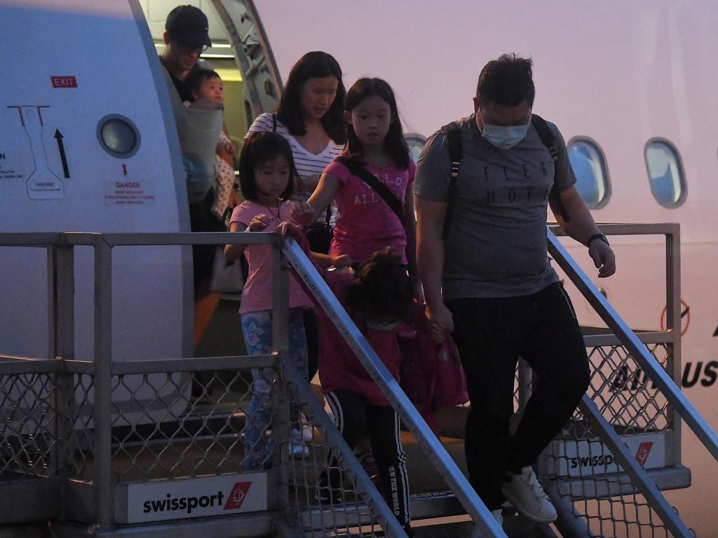 Australian evacuees who were quarantined on Christmas Island get off a plane in Sydney after being cleared of the disease. Picture: AAP Image/Steven Saphore