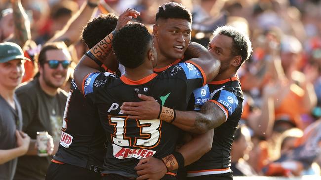 SYDNEY, AUSTRALIA - APRIL 14:  Stefano Utoikamanu of the Tigers celebrates with team mates after scoring a try during the round six NRL match between Wests Tigers and St George Illawarra Dragons at Campbelltown Stadium, on April 14, 2024, in Sydney, Australia. (Photo by Matt King/Getty Images)