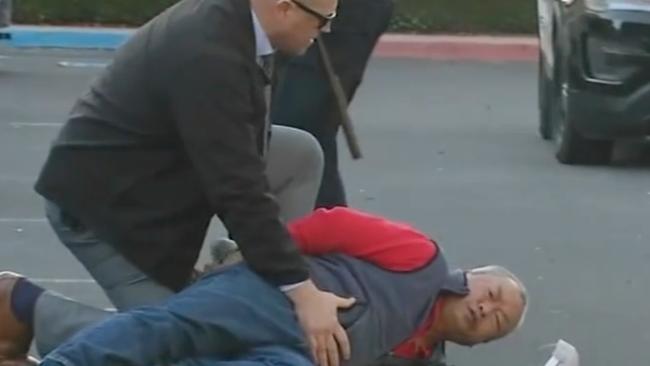 Officers take a man identified as Zhao Chunli into custody after he drove to a sheriff's office media staging area following multiple shootings in Half Moon Bay that left at least seven people dead. Picture: ABC affiliate KGO