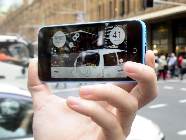 Measuring the speed of traffic on the corner of Market and George Street, using a speed calculating smart phone app. Speed limits in the city will be dropped to 40km/h by the end of the year. Picture: John Appleyard