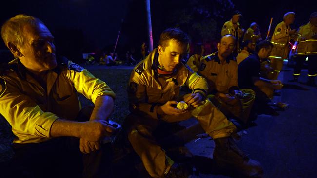 Weary firefighters take a break from battling bushfires in Nana Glen, near Coffs Harbour. Picture: AAP