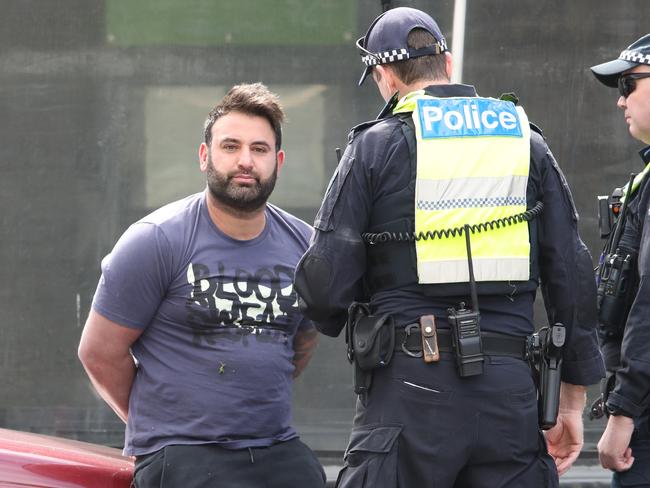 Police speak to a man, believed to be a relative of one of the victims. Picture: David Crosling