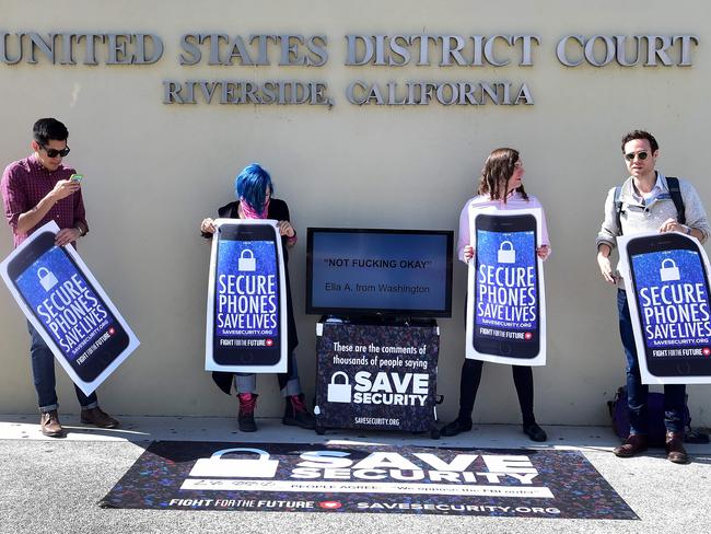 L-R: Activists Luis Nolasco, Aki Rose, Evan Greer and Josh Rabb hold placards reading "Secure Phones Saves Lives" during a protest in front of the US District Court. Picture: AFP/ FREDERIC J. BROWN