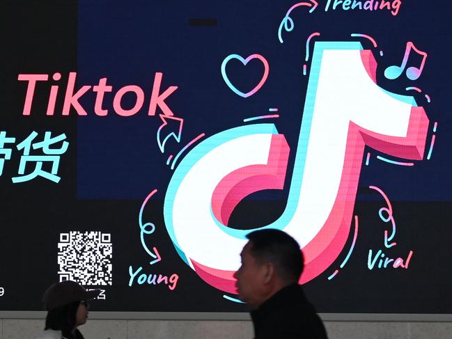 People walk past an advertisement featuring the TikTok logo at a train station in Zhengzhou, in Chinaâs central Henan province on January 21, 2024. China on March 14, 2024 slammed the approval of a US bill that would ban TikTok unless it severs ties with its Chinese parent company, blasting Washington's "bandit" mentality and vowing Beijing would "take all necessary measures" to protect the interests of its companies overseas. (Photo by GREG BAKER / AFP)