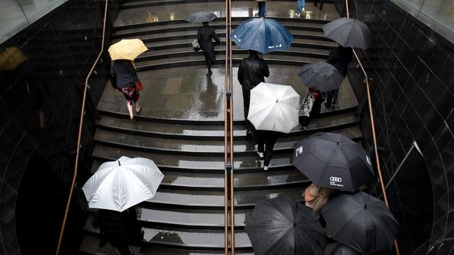 Office workers are seen during wet weather in Sydney. Picture: AAP Image/Mick Tsikas