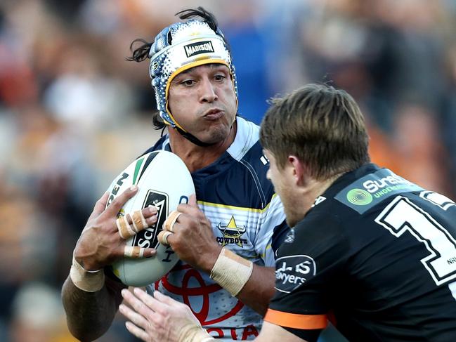 Johnathan Thurston tackled by Tigers Chris Lawrence during the Round 22 NRL game between the Wests Tigers and the North Queensland Cowboys at Leichhardt Oval . Picture : Gregg Porteous
