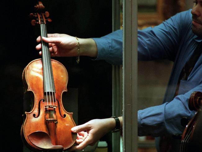 06/05/2000 PIRATE: 05/05/2000. The 300-year-old Stradivarius violin, known as "The Taft", is delicately removed from a display case before its auction at Christie's in New York. It was sold for US$1,326,000 to an anonymous bidder. musical instruments.