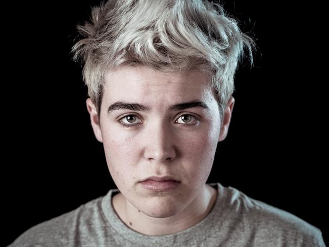 Young sad trans teenager boy suffering from depression feeling sad and desperate. Depressed transgender teen in distress In Mental health, Depression and gender identity and human rights concept.