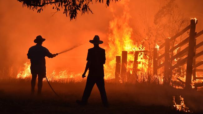 A file photo taken on November 12, 2019 shows residents defending a property from a bushfire at Hillsville near Taree, 350km north of Sydney. Picture: Peter Parks