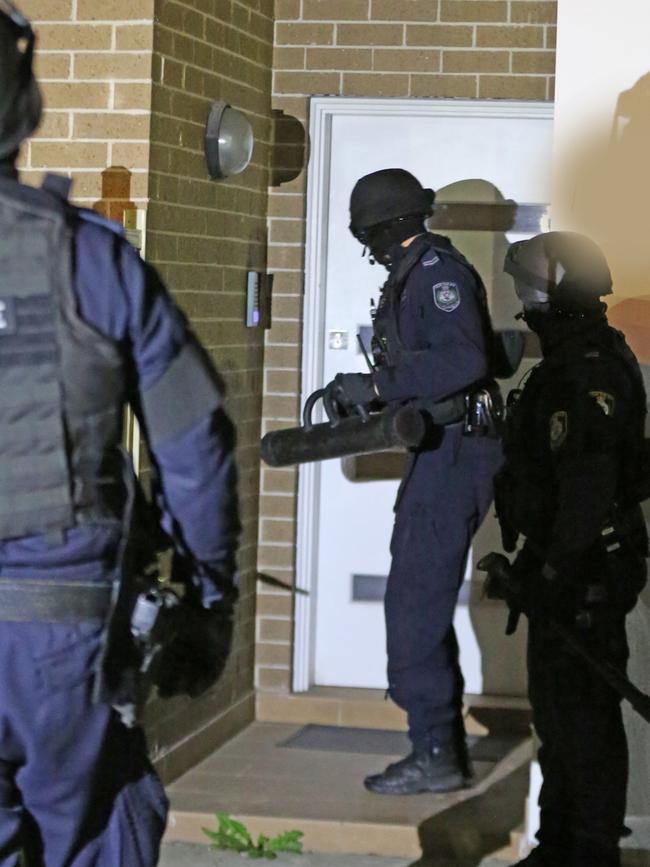 NSW Police enter a home at Greenacre just after 6am today.