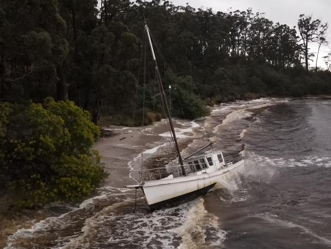 A boat washed up on the beach at Surveyors Bay, near the Huon River, after wild wet weather on Sunday. Picture: Ethan O'Neal