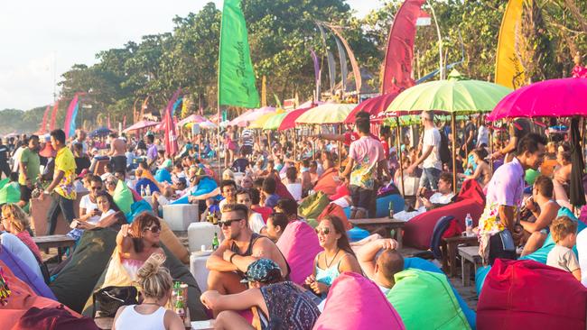 Tourists enjoy a drink in a beach bar along Seminyak beach, just north of Kuta, in Bali.