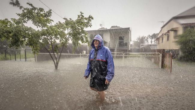 Frank Pery amid a downpour outside his Railway Estate house, Townsville. Picture: Glenn Hunt 