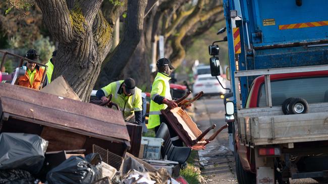 Cleaning crews are starting to load up rubbish into trucks around the streets effected by flooding in Maribyrnong. Picture: Tony Gough