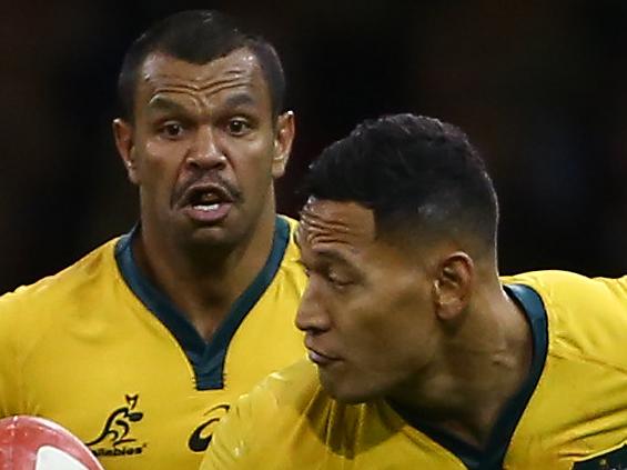 Australia's wing Israel Folau (C) offloads the ball to Australia's centre Kurtley Beale (L) during the international rugby union test match between Wales and Australia at the Principality stadium in Cardiff, south Wales, on November 10, 2018. (Photo by GEOFF CADDICK / AFP) / RESTRICTED TO EDITORIAL USE -use in books subject to Welsh Rugby Union (WRU) approval