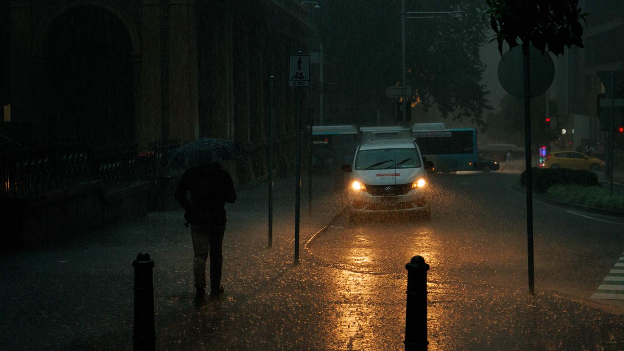 A person shelters under their umbrella on King Street, Sydney on Wednesday. Picture: NCA NewsWire / Max Mason-Hubers