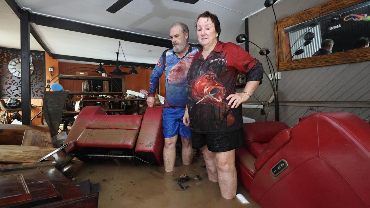 David and Tracy Ebert look for items to salvage from the lounge room, after flood water inundated their Cardwell home overnight. Picture: Brendan Radke