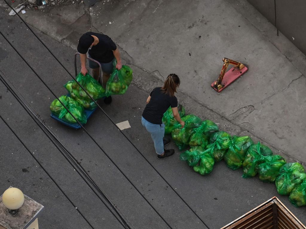 Residents take bags with vegetables at the entrance of a neighbourhood during a lockdown in the Jing'an district in Shanghai. Picture: AFP