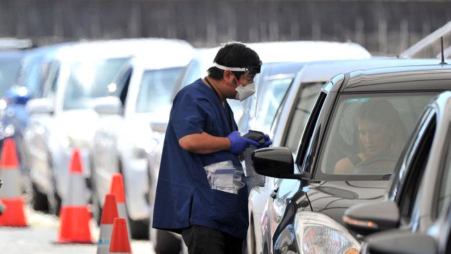 A health official collects a Covid-19 swab test at a drive-through testing site on Bondi beach in Sydney. Picture: AFP