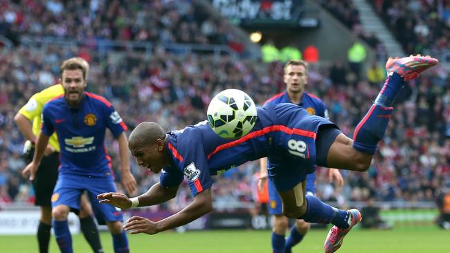 Manchester United's English midfielder Ashley Young falls to the ground after a challenge by Sunderland's English defender Wes Brown during the English Premier League football match between Sunderland and Manchester United at The Stadium of Light in Sunderland, north-east England on August 24, 2014. AFP PHOTO / IAN MACNICOL RESTRICTED TO EDITORIAL USE. No use with unauthorized audio, video, data, fixture lists, club/league logos or “live” services. Online in-match use limited to 45 images, no video emulation. No use in betting, games or single club/league/player publications.