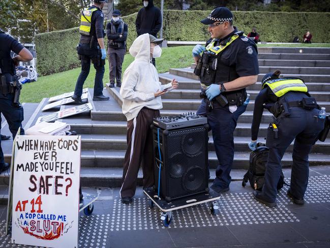 Police talk to a protester before the rally kicked off. Picture: Jake Nowakowski
