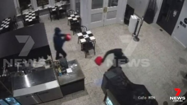 The two hooded men spread accelerant on the floor and furniture in the Prospect creperie. Picture: 7NEWS