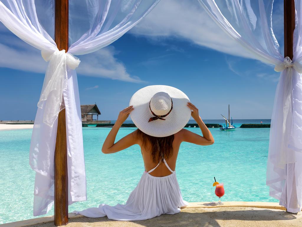 Beautiful woman with white hat enjoys her summer holiday in the tropics