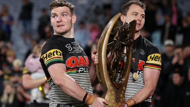 Liam Martin and Dylan Edwards hold the NRL premiership trophy. Picture: Cameron Spencer/Getty Images