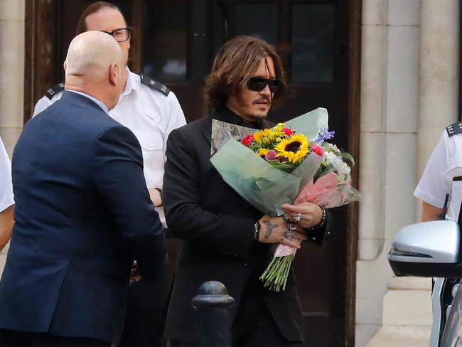 With a bouquet of flowers, given to him by a fan. Picture: AFP