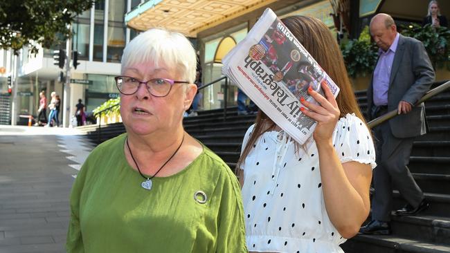 Cahill hid behind a copy of today’s paper as she left court. Picture: NCA Newswire / Gaye Gerard