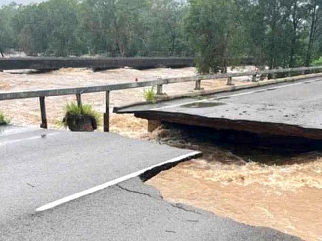 The Bruce Highway’s Ollera Creek Bridge north of Townsville has been cut in half by flood water.